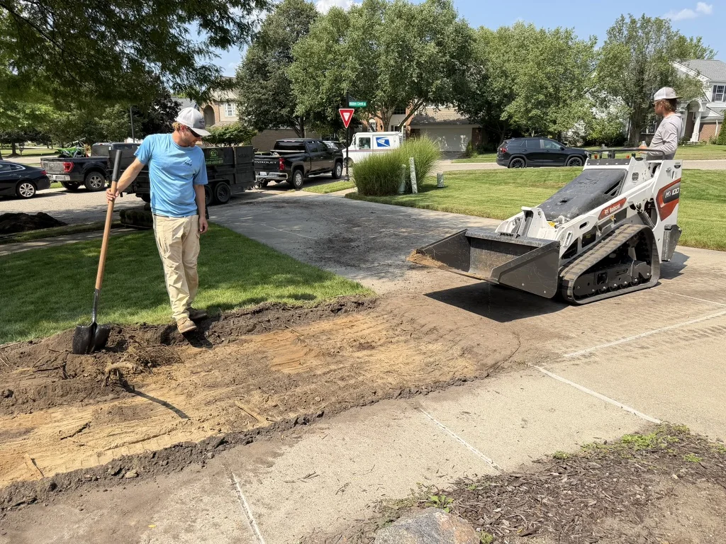 Total 1 crew preparing a residential lawn area with compact equipment and hand tools